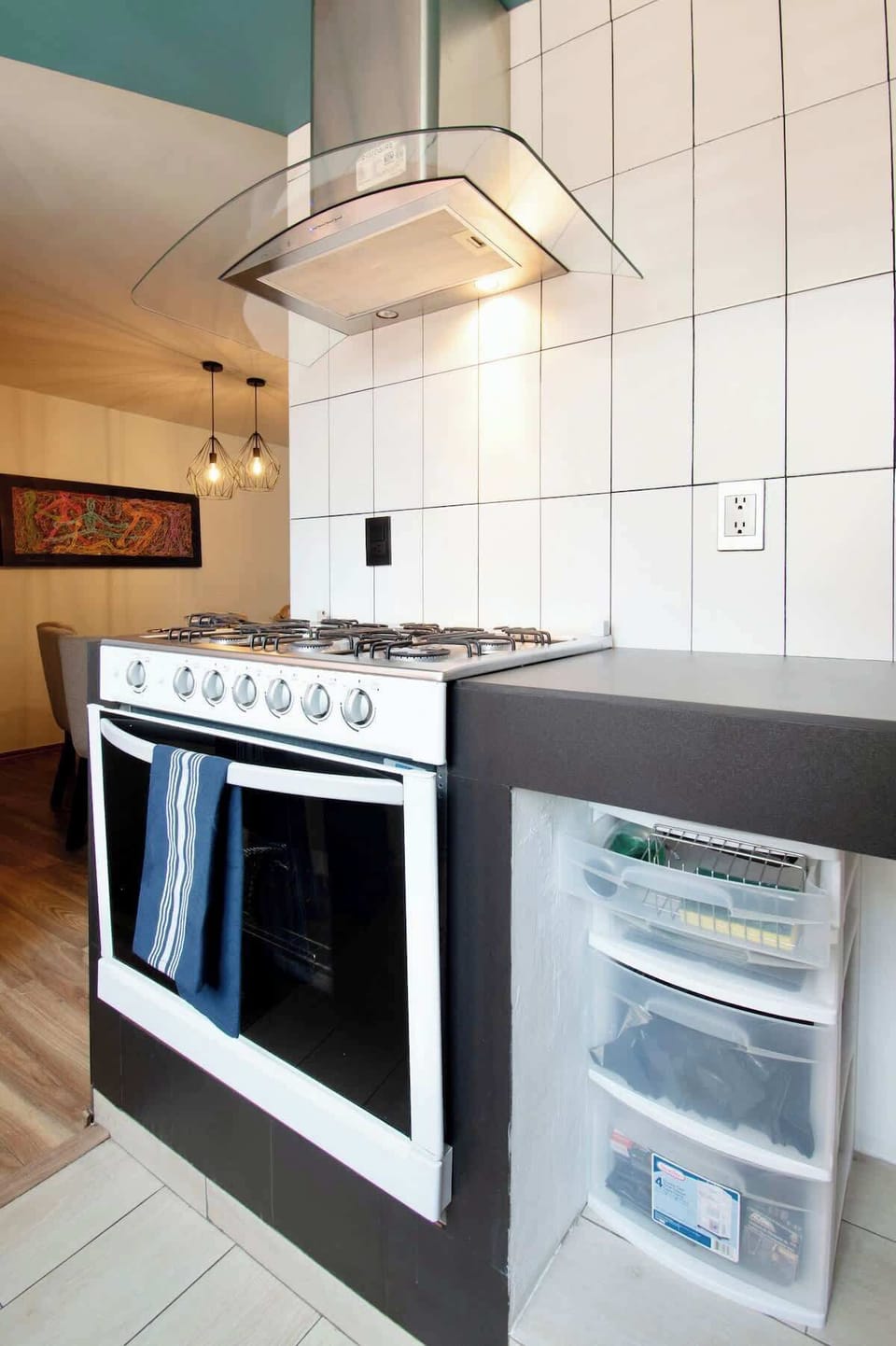 Fully equipped stove with modern hood, seamlessly connected to the dining area for easy cooking.