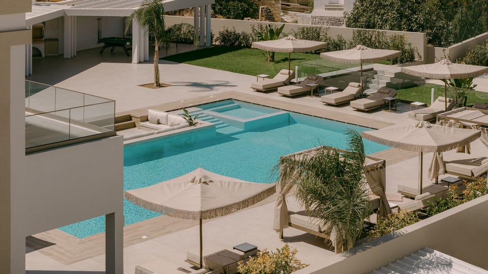 A pool that stretches like a dream — featuring an in-pool lounge area.