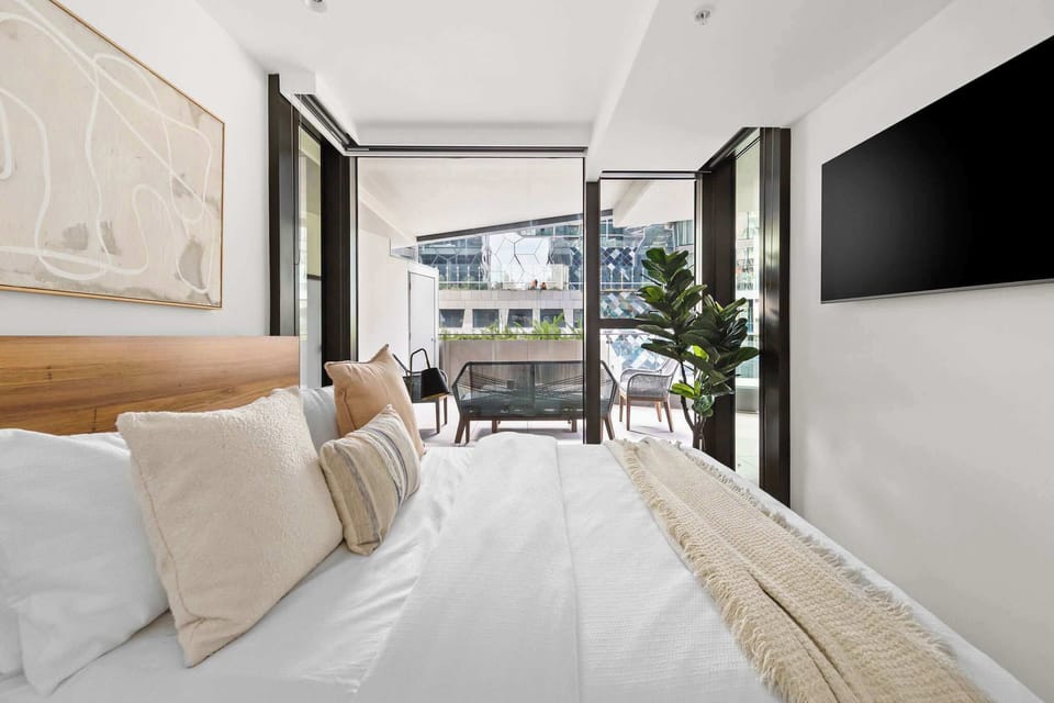 The 2nd bedroom with a queen sized bed, plush pillows & a 55" QLED smart TV.
