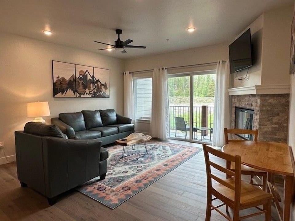 Relax in the spacious living room with cozy seating, fireplace, and bright natural light.