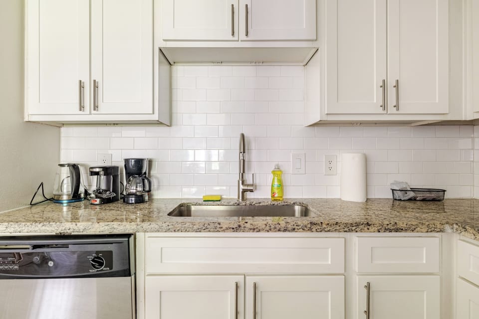 Bright modern kitchen with granite counters and coffee station