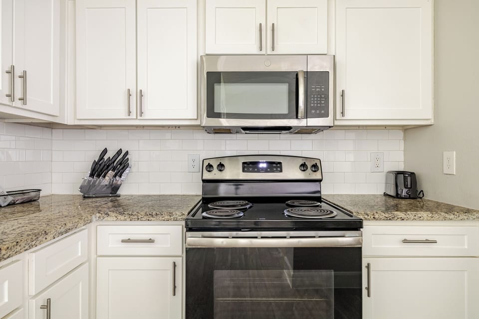 Bright modern kitchen with granite counters and stainless appliances
