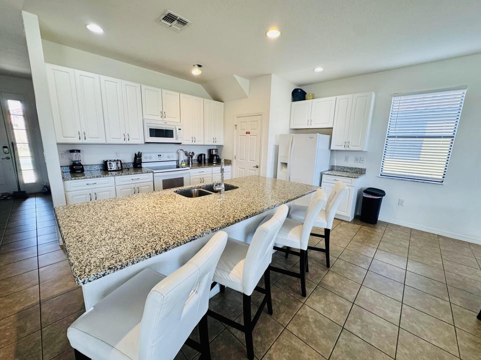 Bright, spacious kitchen with granite island and cozy seating