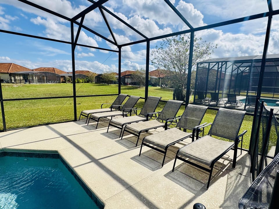 Sunlit poolside patio with ample lounge seating for relaxation