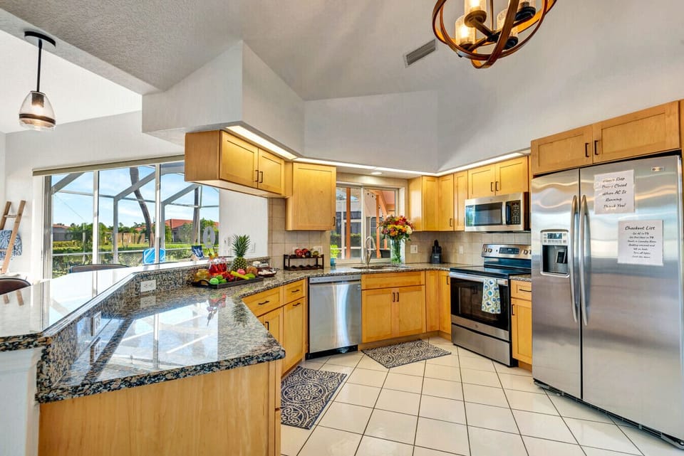 Kitchen | Granite Countertops, Stainless Steel Appliances, and Poolside View with Breakfast Bar