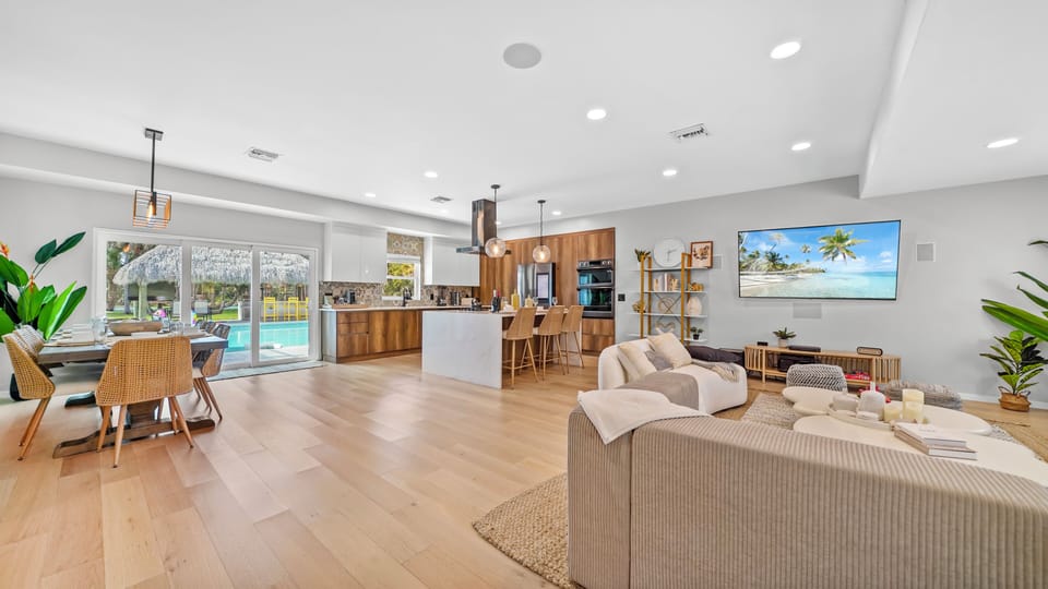 Wide shot of open living area with sliding glass doors to pool and backyard