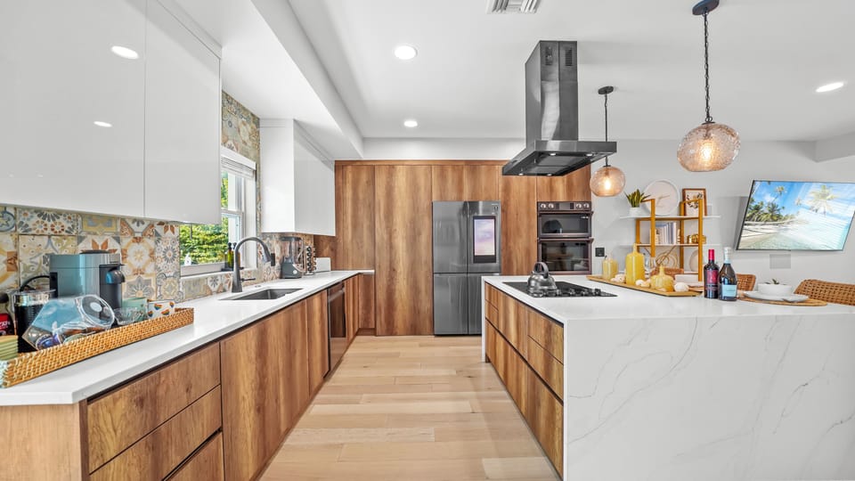 Galley kitchen with long cabinets and island - plenty of prep space & fridge.