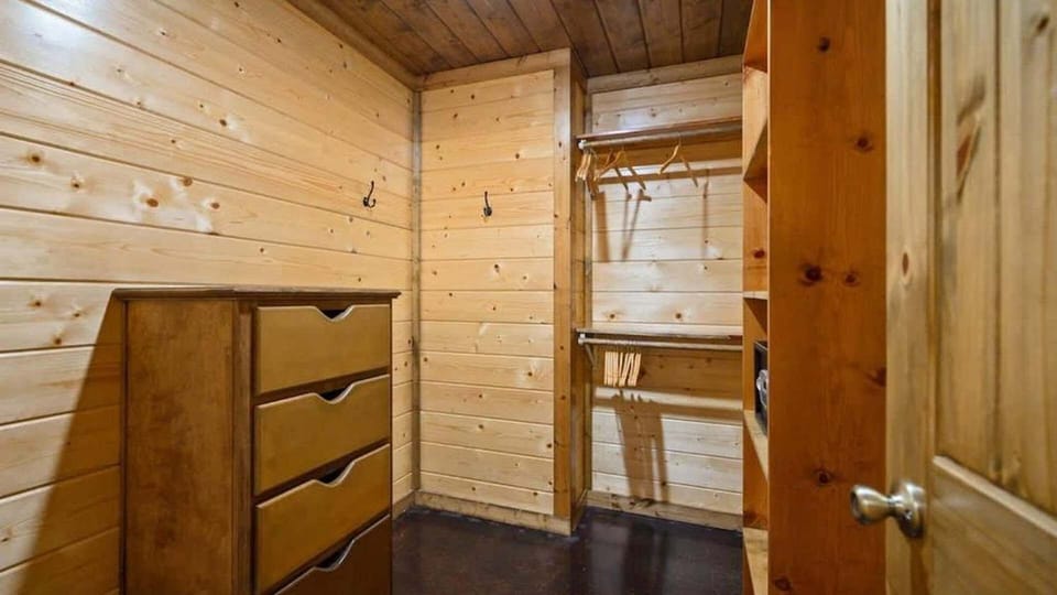 Spacious walk-in closet with shelves and hangers for extended cabin stays.