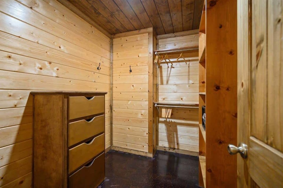 Spacious walk-in closet with shelves and hangers for extended cabin stays.