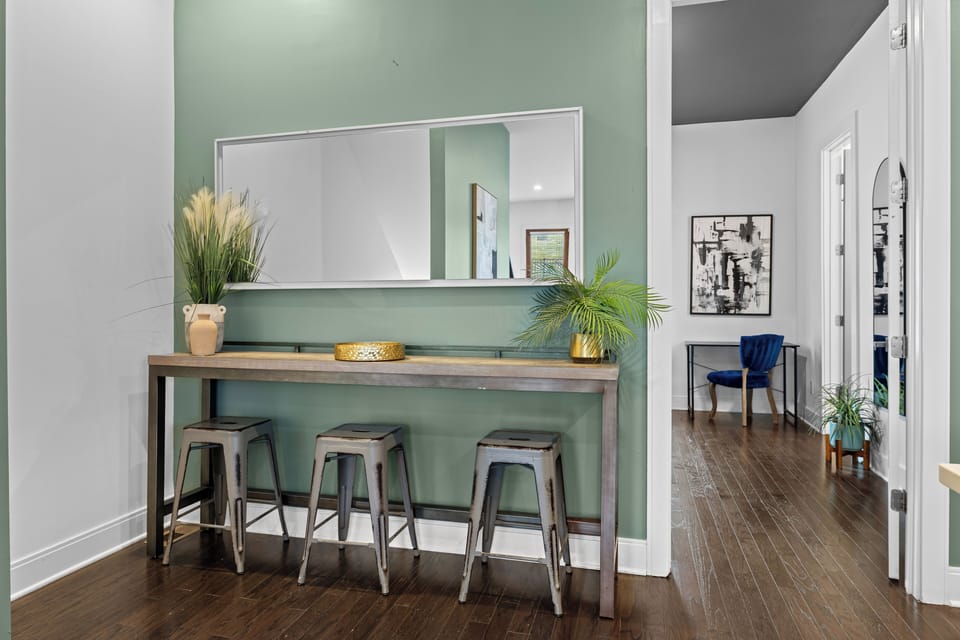 Stylish entry with bar console, large mirror, and adjacent workspace.
