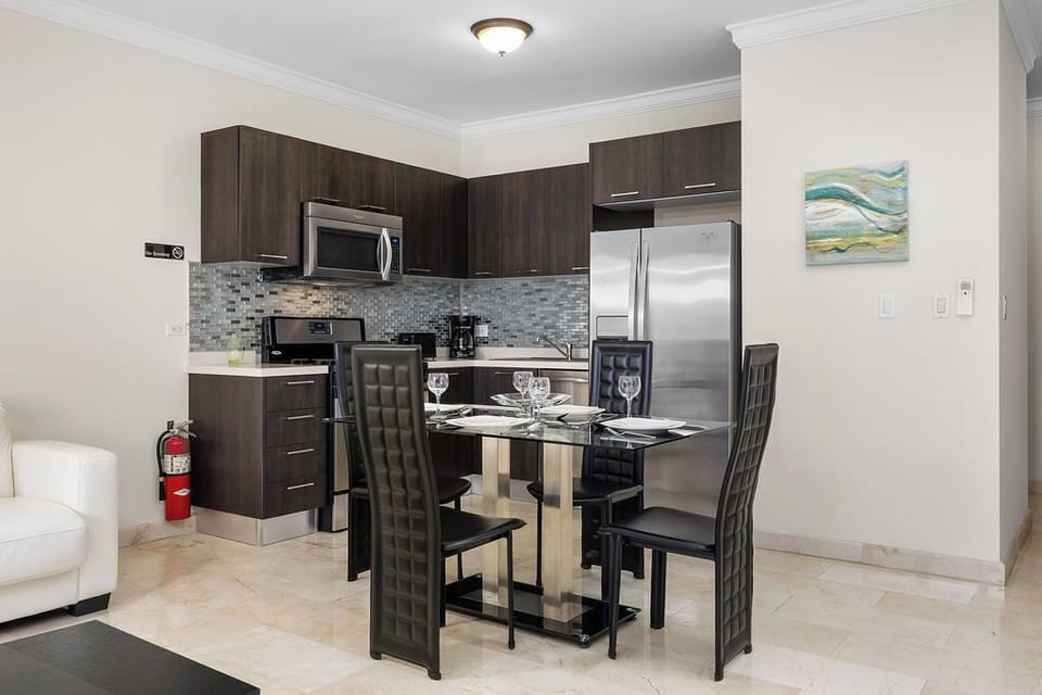 This seamless dining area offers both style and convenience. Featuring a sleek glass table and comfortable seating for four, it's just steps from the full stainless steel kitchen. Everything you need for an effortless, enjoyable stay is right here.