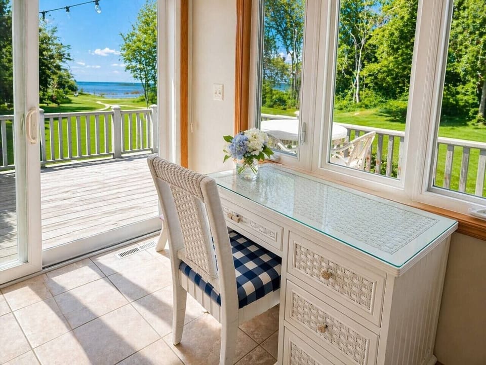 Sunroom workspace with stunning lake views—perfect for remote work, morning emails, or quiet moments surrounded by natural light.