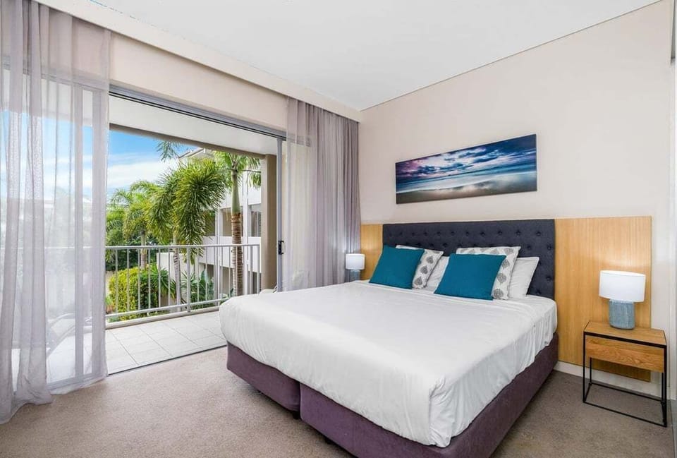 Peaceful and airy bedroom with balcony access, perfect for unwinding after a long day.
