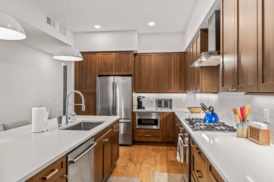 Fully equipped with professional stainless steel appliances, including a gas range and an oversized refrigerator.