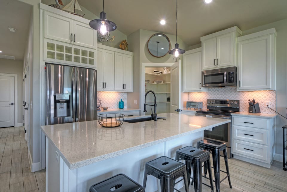 Kitchen with barstool seating and modern appliances.