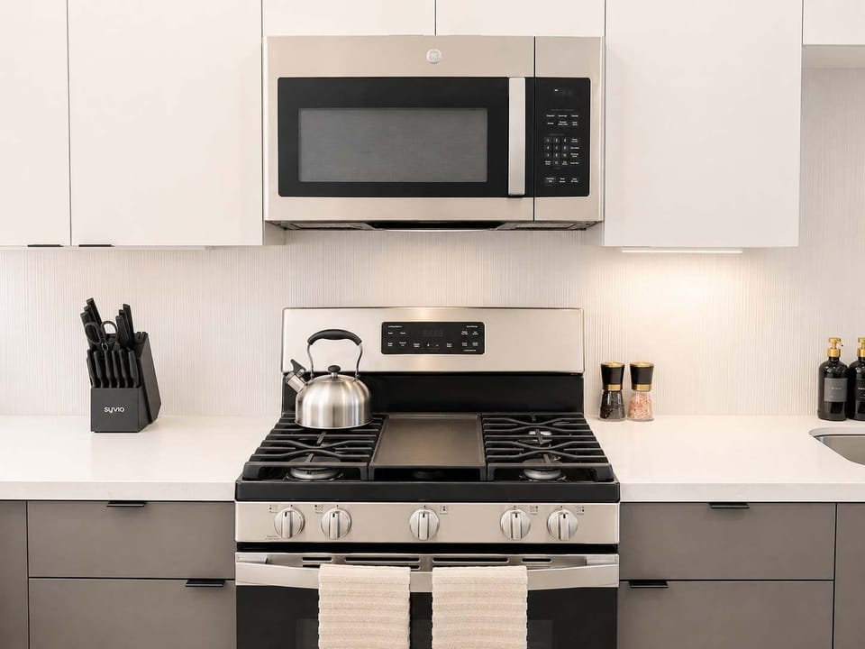 Experience extended comfort with a fully equipped kitchen featuring a coffee machine, stovetop, and microwave—everything you need for a seamless long-term stay