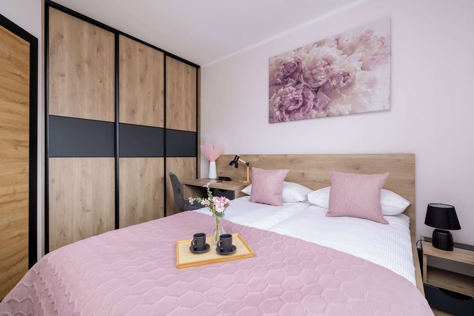 Another bedroom features a bed with pink bedding, a wooden headboard, and a large closet with sliding doors.