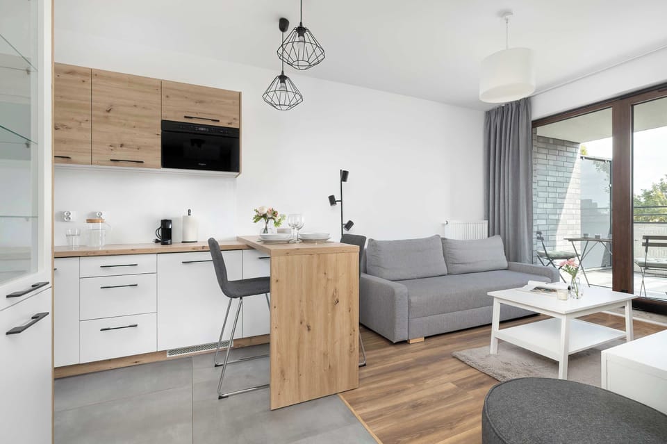 Modern kitchen with an island and wooden fronts encourages cooking in a warm, homely atmosphere.