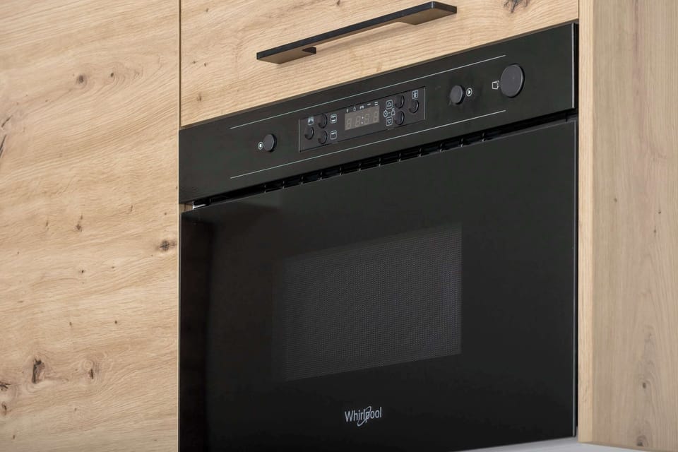 The black oven contrasts with the light cabinetry, adding elegance and a modern touch to the space.