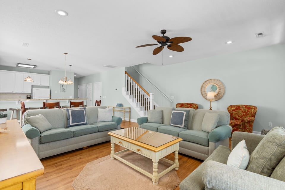 Relax in your spacious living room with plush seating, warm hardwood floors, and coastal charm that makes every evening feel like a getaway.
