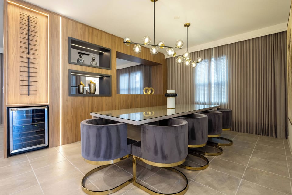 Join us at the stylish dining table, surrounded by plush velvet chairs and warm wood paneling. The inviting ambiance, complemented by soft lighting, is ideal for enjoying leisurely meals and engaging evening conversations.
