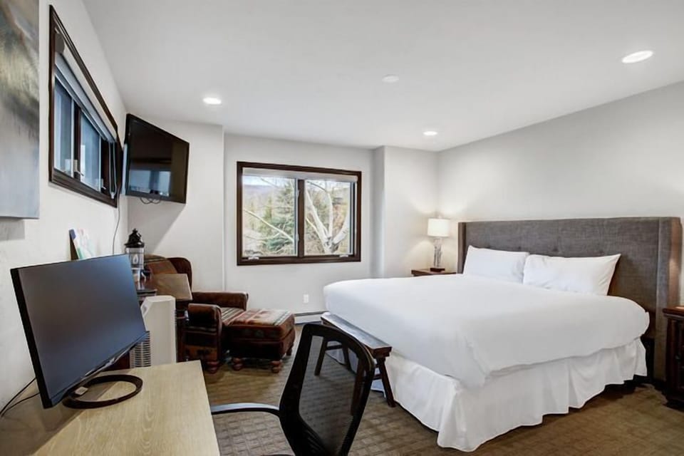 Another inviting bedroom space, equipped with a workstation and large windows, offering a tranquil view of the surrounding landscape.