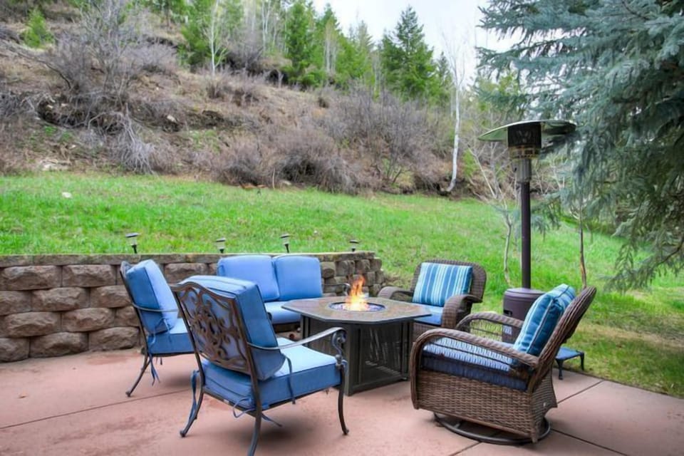 The inviting outdoor patio is an ideal spot to unwind, featuring comfortable seating and a fire pit that enhances the breathtaking mountain backdrop.