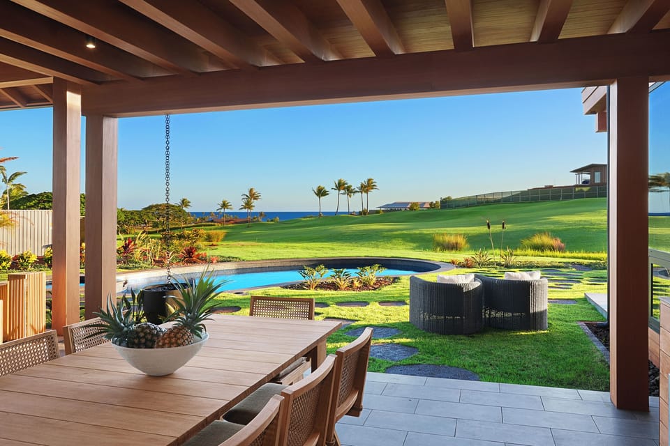 Covered outdoor dining area with built-in grill and sunset views—perfect for alfresco evenings overlooking the pool and fairways.