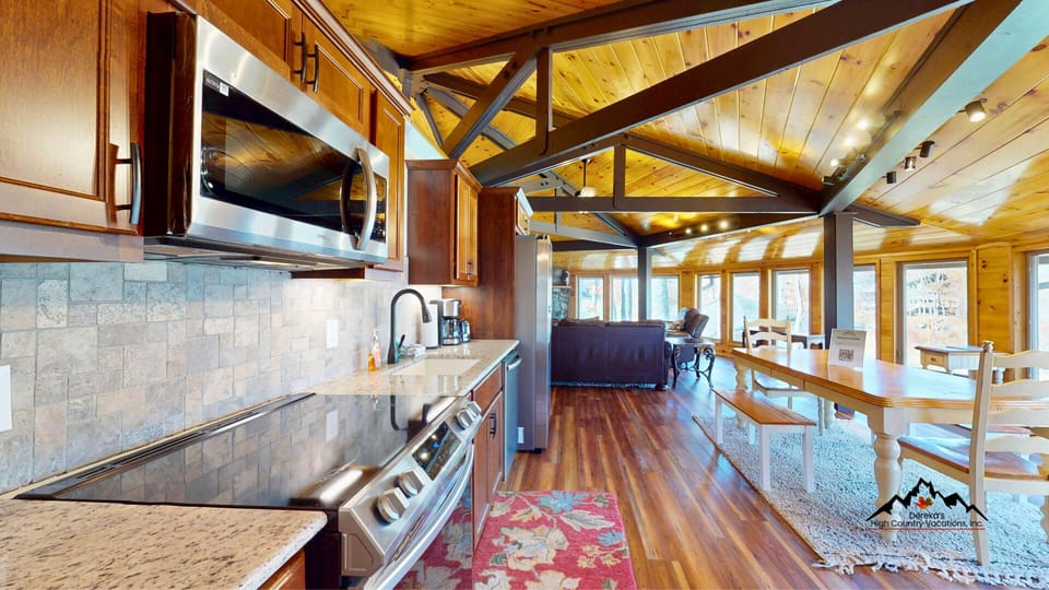 The open kitchen and dining area flows seamlessly into the living room, creating the perfect gathering space for meals and mountain memories.
