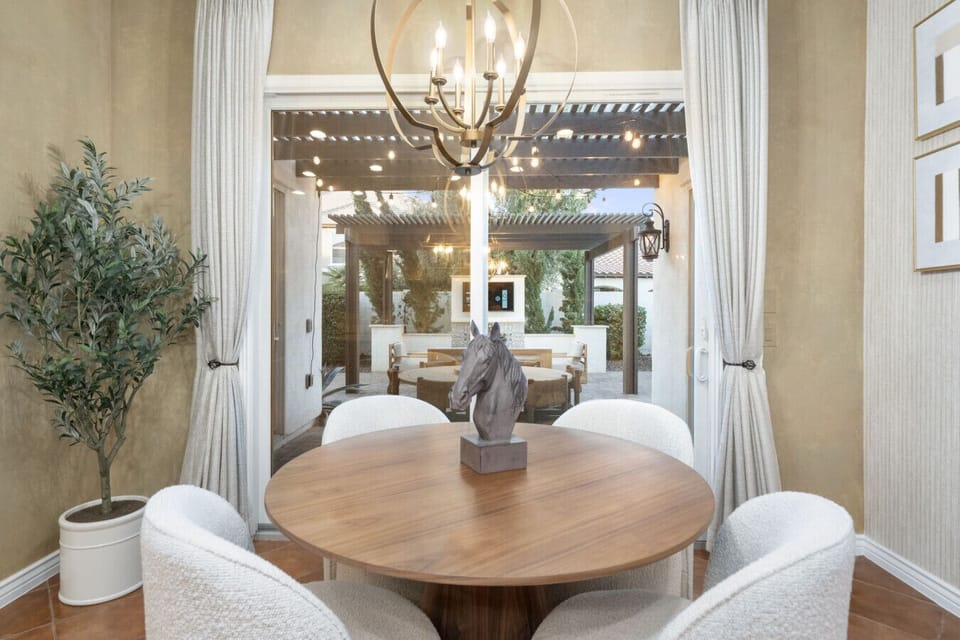 Sunlit dining nook w/ round table, greenery & an indoor-outdoor vibe