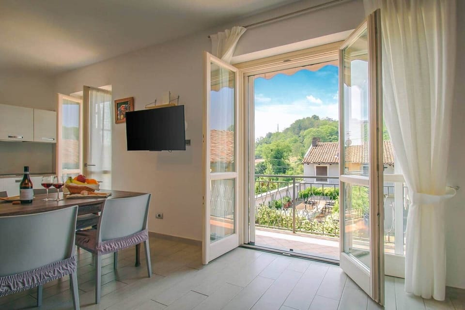 Ampio e luminoso soggiorno con cucina,  accesso su balcone e vista sulle colline