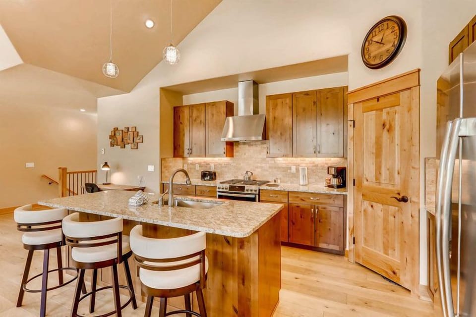A chef’s delight: the gourmet kitchen features gleaming granite counters, stainless steel appliances, and warm wood finishes perfect for après-ski feasts.