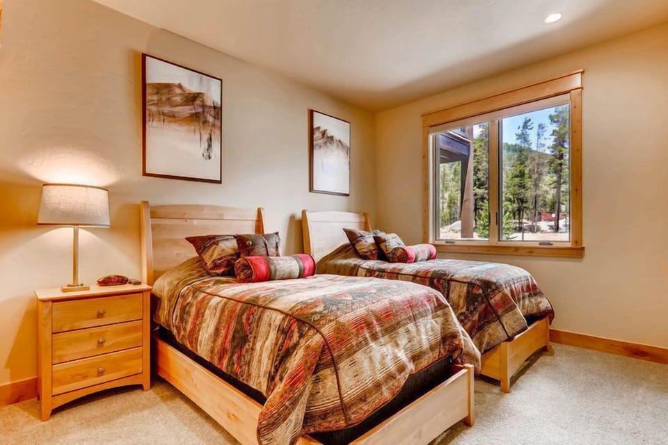 A cozy, mountain-inspired guest room offering comfort and flexibility for any group. Please note that bedding configurations may vary.