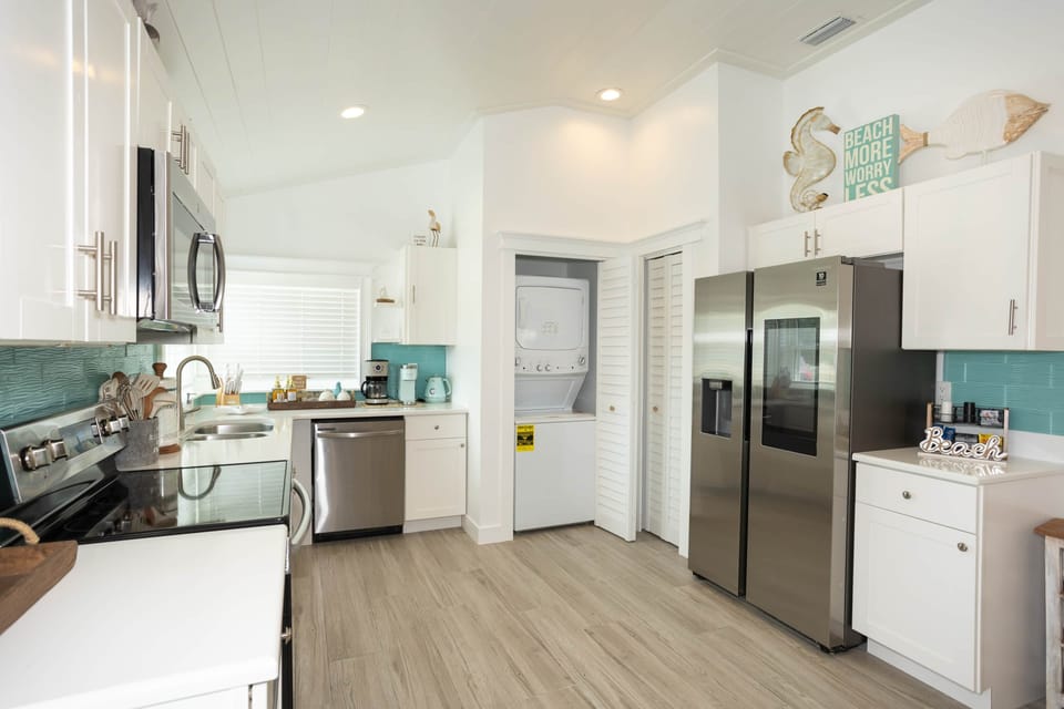 Sunlit open-concept kitchen—white, airy, and made for easy AMI vacation meals.
