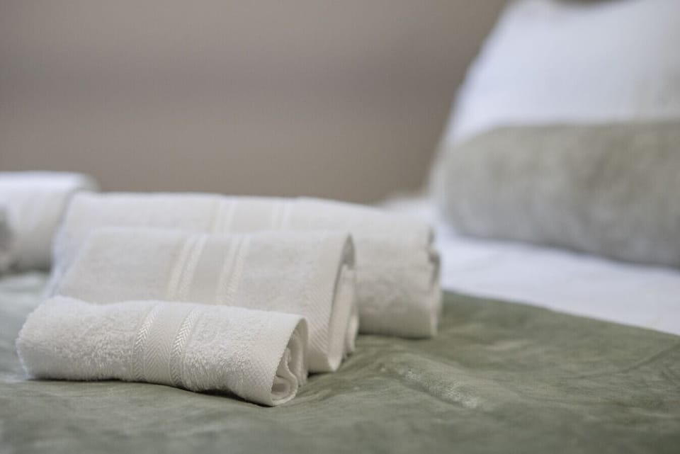 Bedroom 2 | Fresh Rolled Towels on Soft Green Throw