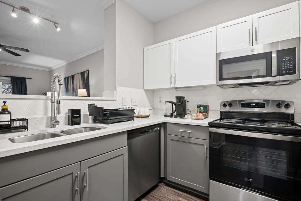 Another view of the fully stocked kitchen — sink, dishwasher & coffee station