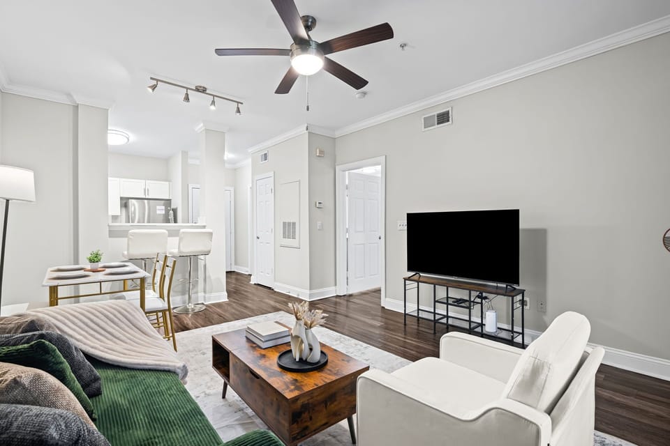 Luxury living room — hardwood floors, smart TV, designer sofa & open dining