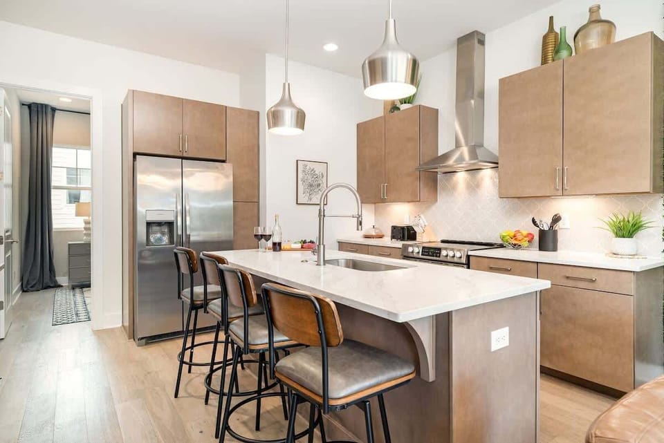 2nd Floor: Fully equipped kitchen, complete with stainless-steel appliances and a kitchen island with ample counter space and bar seating.
