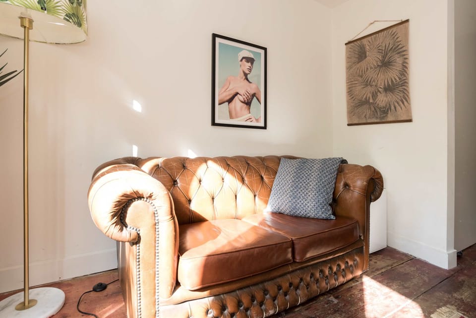 Leather, greenery, and natural light create a warm and inviting vibe.