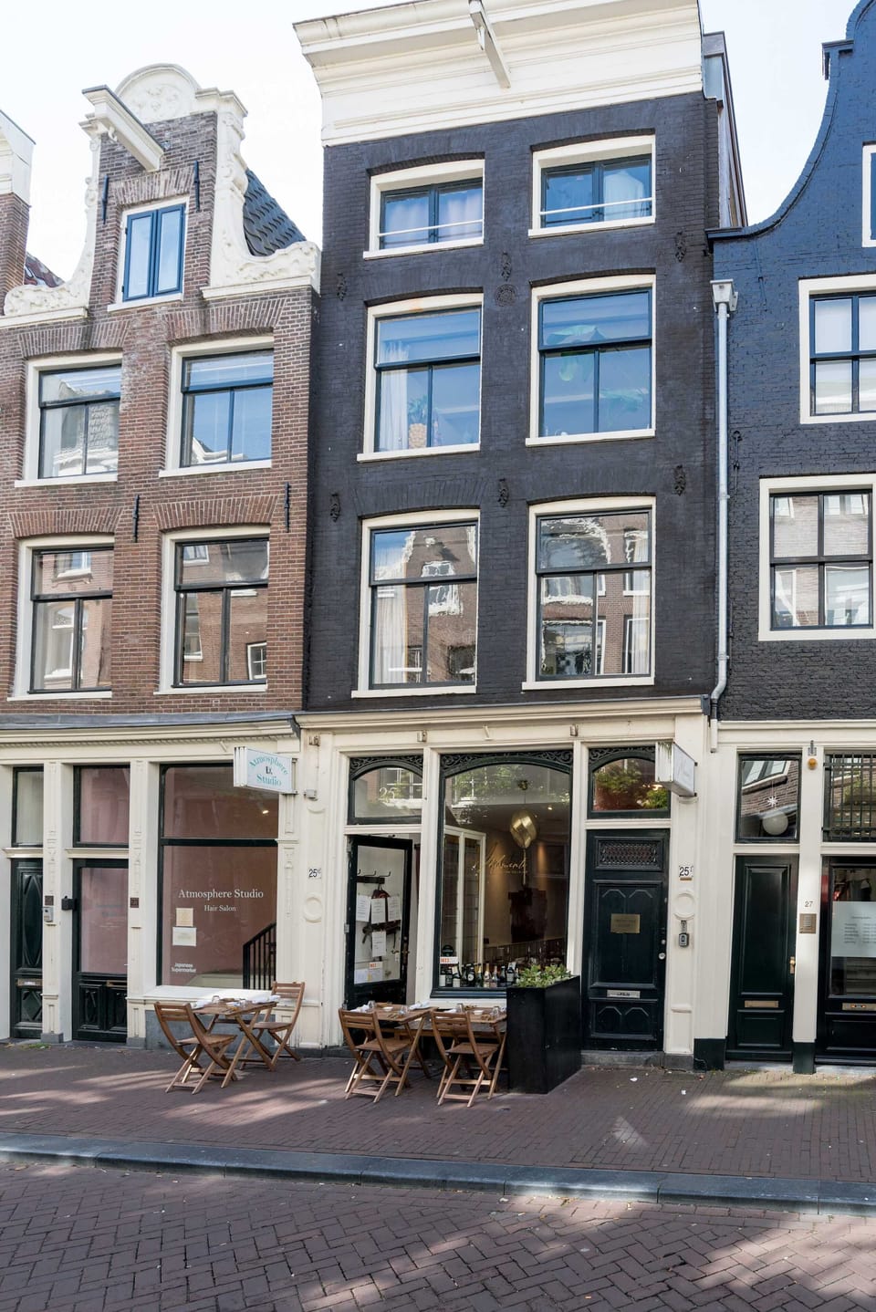 Classic Amsterdam architecture meets stylish street life on this quiet city lane.