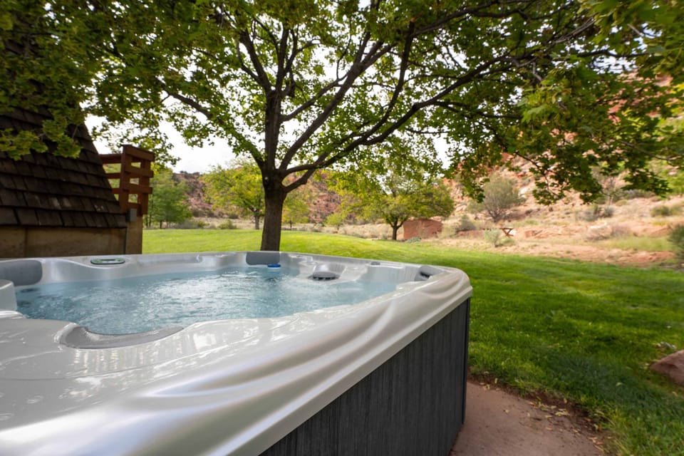 The hot tub gives way to views of the towering red rock hills, the beautiful yard, and the dark starry skies.