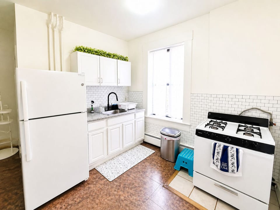 Bright, spotless kitchen with gas range and full-size fridge