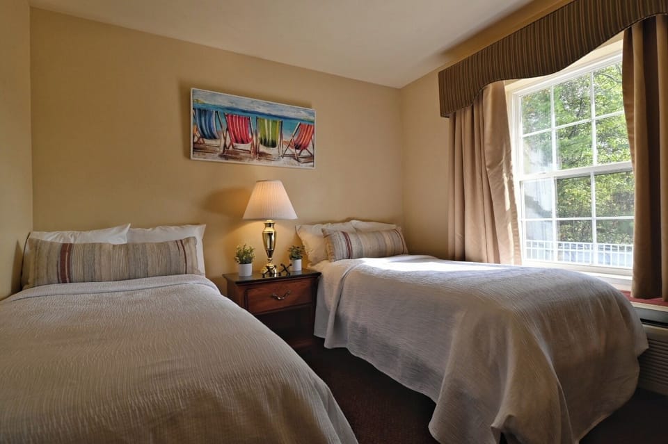 Unwind in twin beds with soft linens and morning light.
