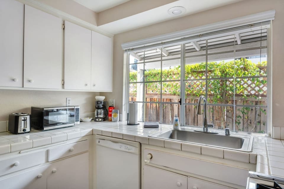 Sunny kitchen with large windows and a view of the private patio.