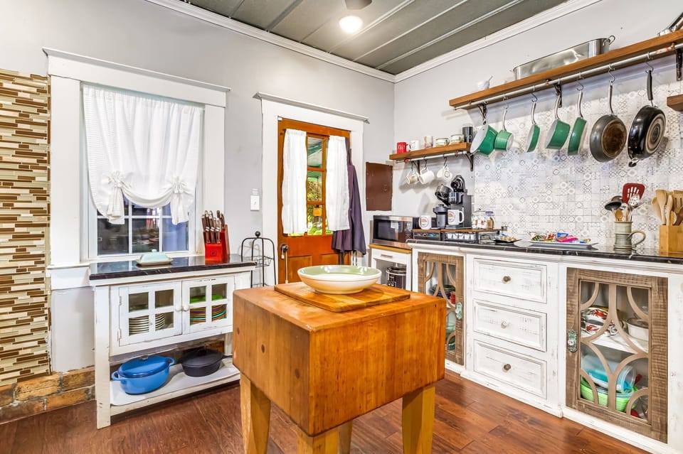 Fully stocked East Hill kitchen with gas stove, open shelving, and eclectic charm.  Ideal for cooking family meals during your Pensacola stay.
