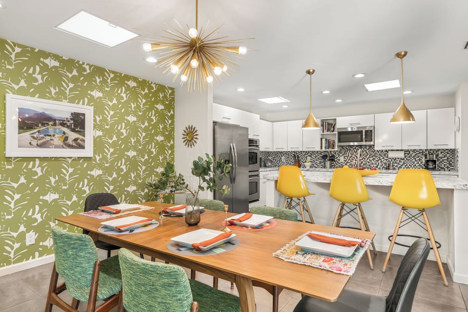 Dining table setup under gold chandelier lighting.