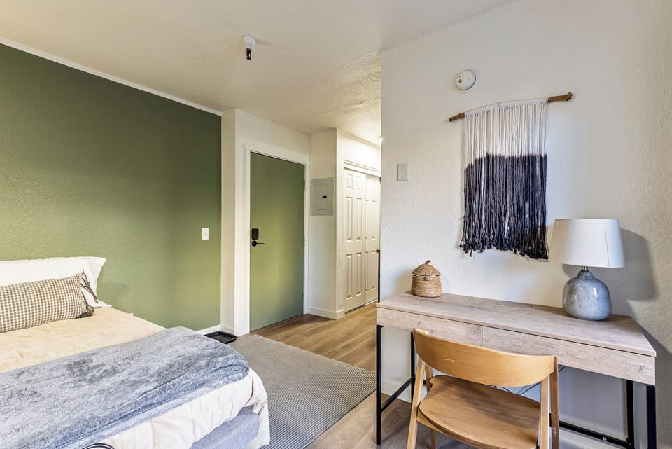 Inviting guest room featuring a queen bed, cozy lighting, and a convenient writing desk — perfect for remote work or planning your next day on the slopes.
