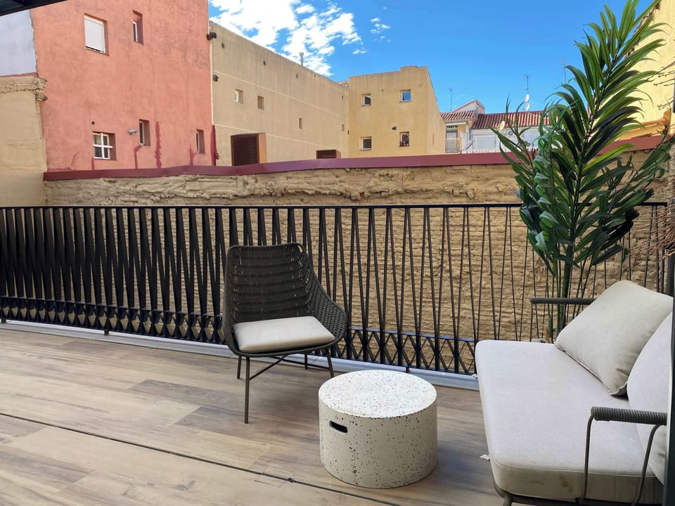 Outdoor terrace with seating and plants.