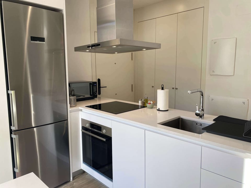 A close-up view of the contemporary kitchen area with stainless steel appliances and hob.