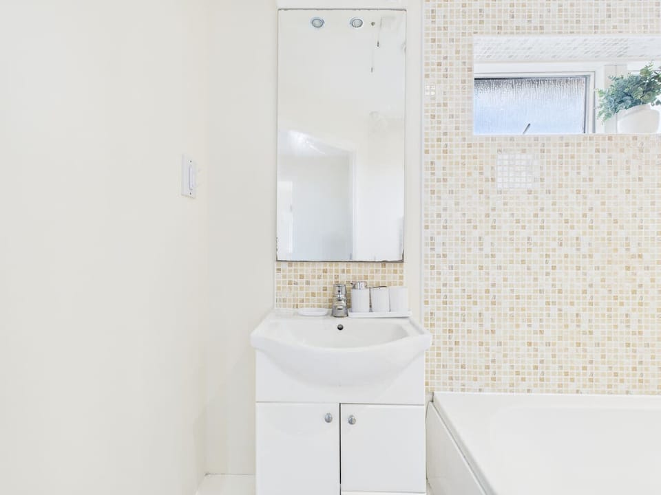Freshen up in the neat bathroom, finished with a bath and modern fittings.